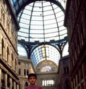 Boy stands at the entrance to a beautiful covered mall.